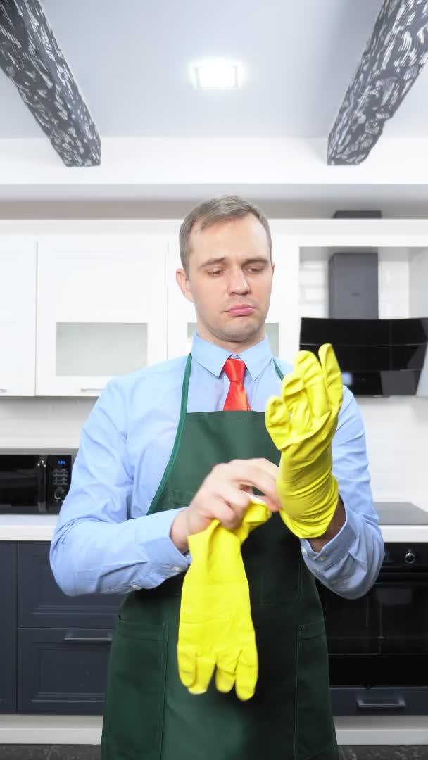 Ein vertikales Bild. schöner Mann in Krawatte und Schürze mit Gummihandschuhen — Stockvideo