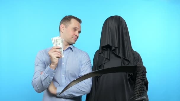 Fantomkép kék háttérrel. halál és ember. Az ember pénzzel fizeti ki a halált. — Stock videók