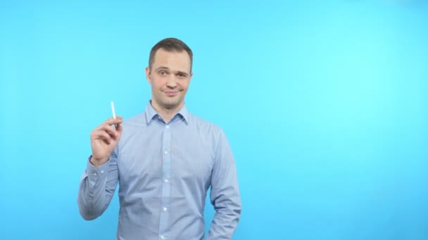Vázlat a kék háttér halál mellett áll egy férfi, aki meggyújtja a cigarettát — Stock videók