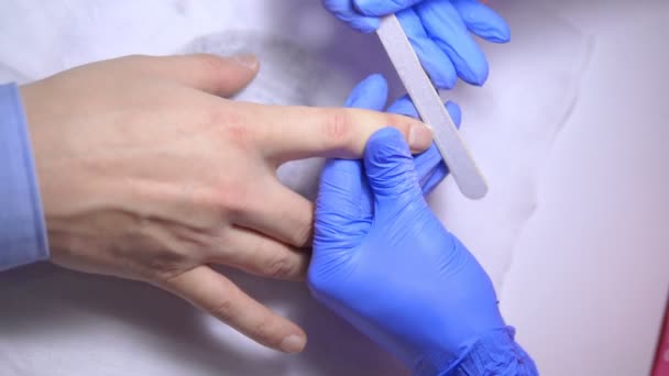 Detailní záběr. manikúra soubory muž nehty s pilníkem nehtů — Stock video