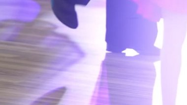 Yakın plan, balo dansı için ayakkabılı çocukların bacakları yerde dans ediyor.