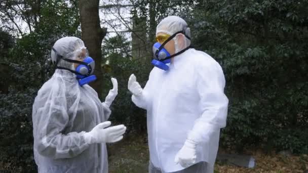 Un uomo e una donna in tuta protettiva e respiratori, andare al parco — Video Stock