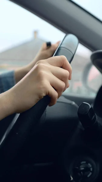 Plan vertical des mains féminines sur le volant d'une voiture en mouvement — Photo