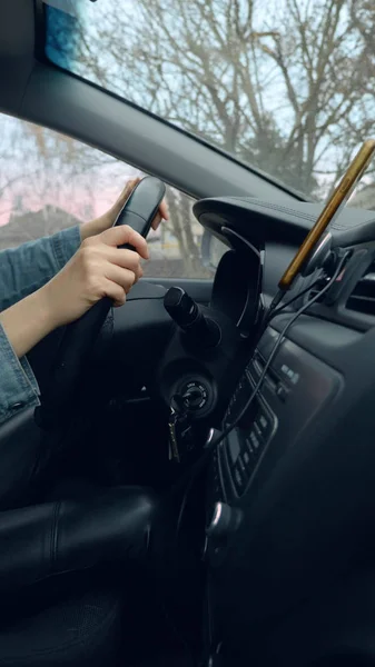 移動中の車のハンドルに女性の手の垂直ショット — ストック写真