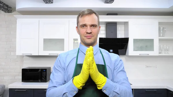 Handsome man in tie and apron wearing rubber gloves — Stock Photo, Image