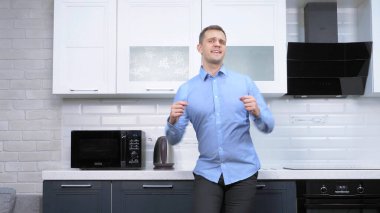 Genç yakışıklı adam mutfakta dans ediyor. Yaşam biçimi