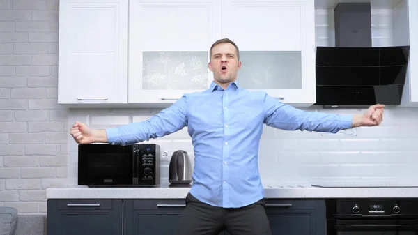 Junger schöner Mann, der in der Küche tanzt. Lebensstil — Stockfoto