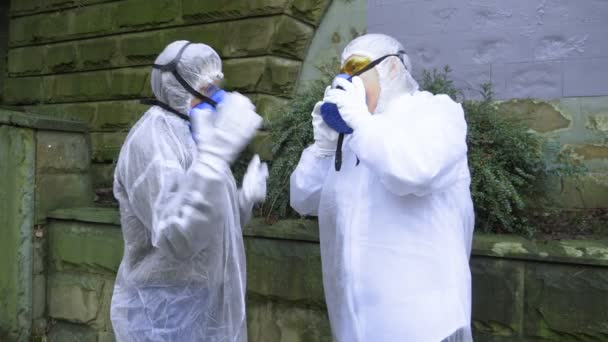 Menschen in Schutzanzügen ziehen ihre Atemschutzmasken aus und beginnen zu ersticken — Stockvideo