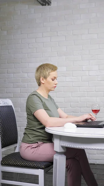 Femme se repose dans la cuisine avec un verre de vin, e cigare utilise un smartphone — Photo