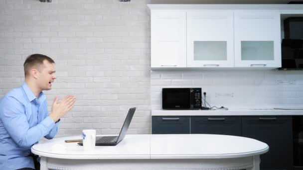Biznesmen korzystający z laptopa siedząc przy stole w kuchni — Wideo stockowe