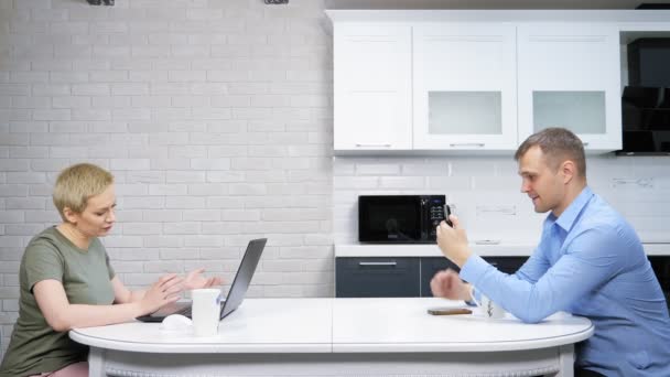 Современная домохозяйка и бизнесмен сидят на кухне, не зная друг друга — стоковое видео