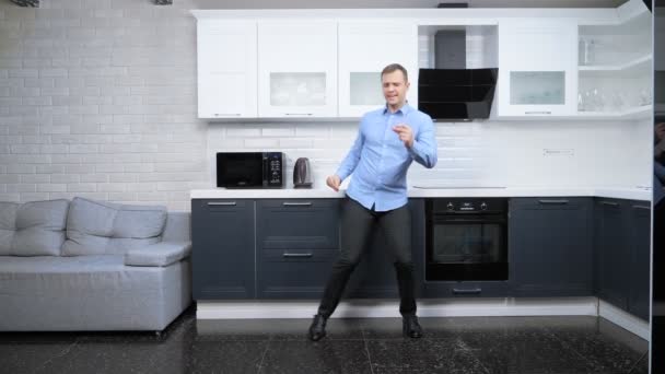 Mladý pohledný muž tančí v kuchyni. životní styl — Stock video