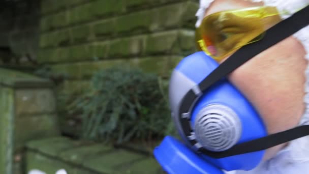 Man and woman in hazmat suits and respirator in the Park. the man gives a flower — Stock Video