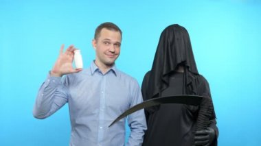 Bir adam vitamin şişesinin yapraklardan öldüğünü gösterir. Vitamin konsepti, diyet