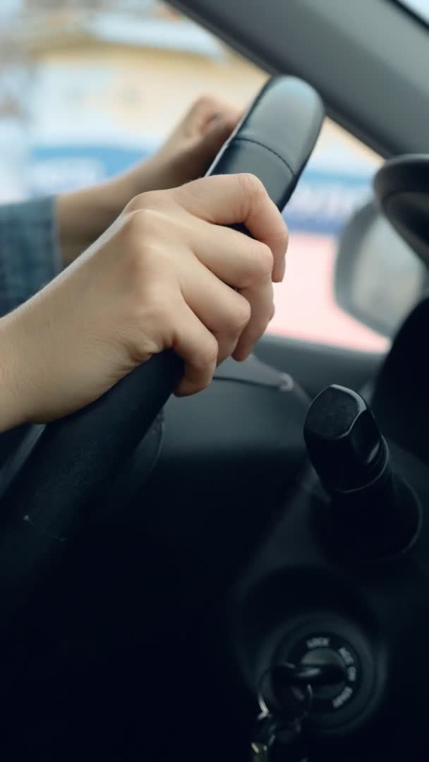 Vertikal skott av kvinnliga händer på ratten i en bil i rörelse — Stockvideo