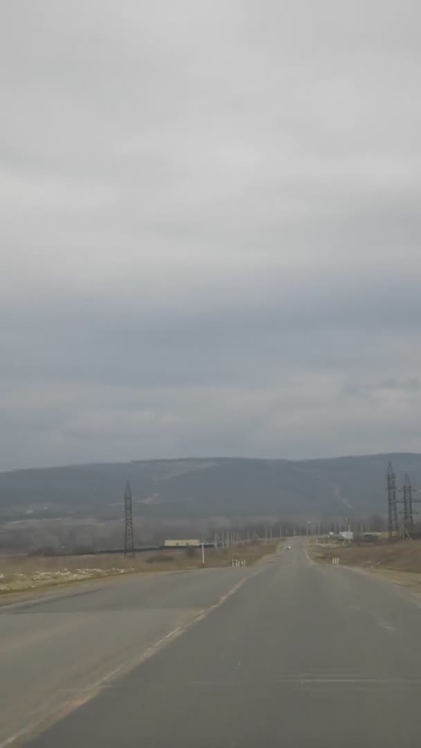 Vista dal finestrino dell'auto. strada vuota tra i campi, il cielo blu e le nuvole — Video Stock