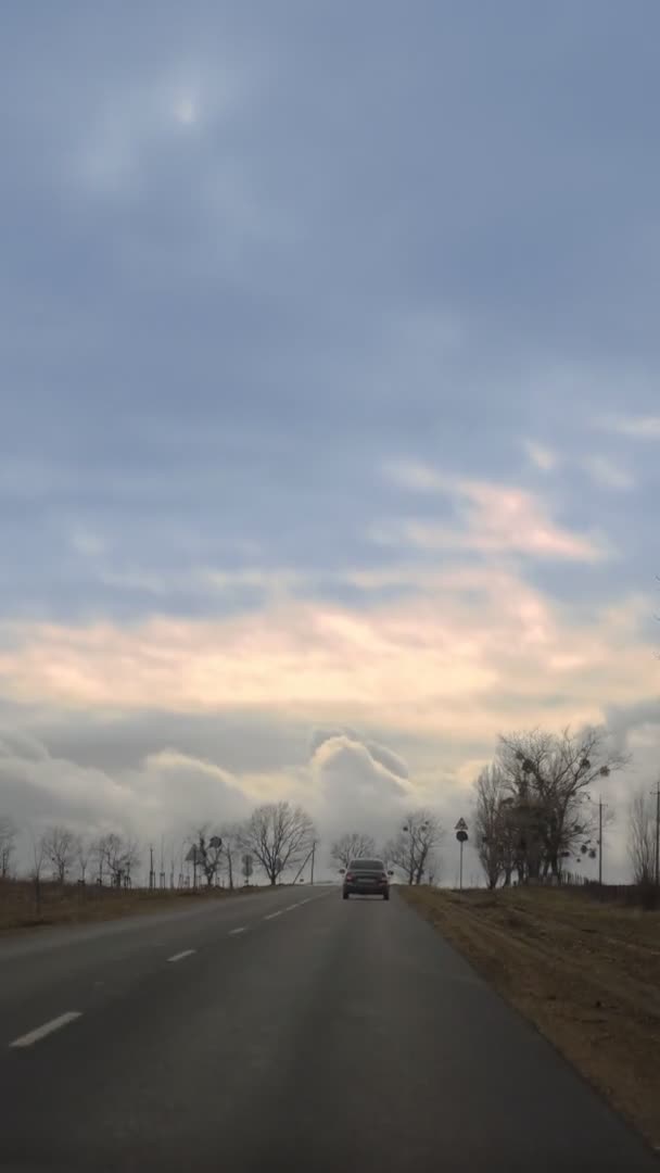 Vista dal finestrino dell'auto. strada vuota tra i campi, il cielo blu e le nuvole — Video Stock