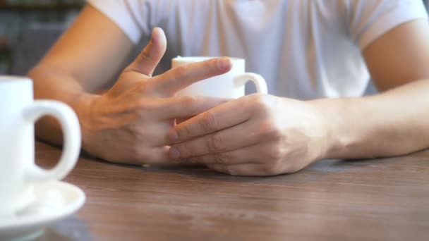 Fechar. homem tira um anel de casamento enquanto sentado em um café . — Vídeo de Stock