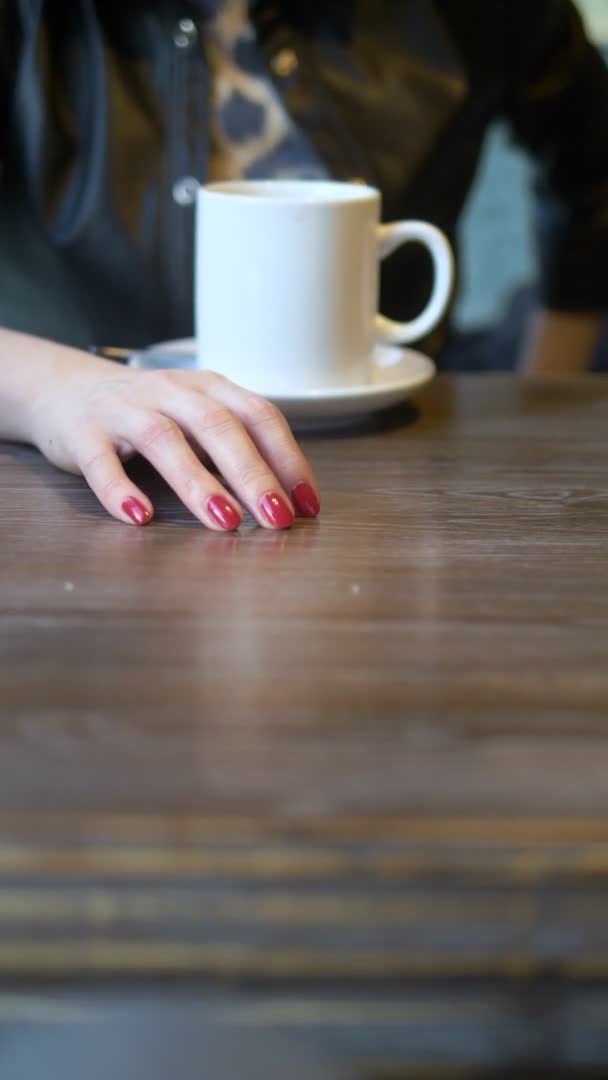 Uma mulher usa uma aliança no dedo, sentada num café. tiro vertical — Vídeo de Stock