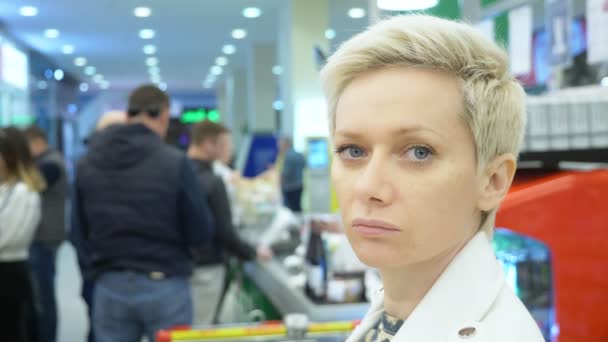 Portret van een vermoeide vrouw in de supermarkt. close-up — Stockvideo
