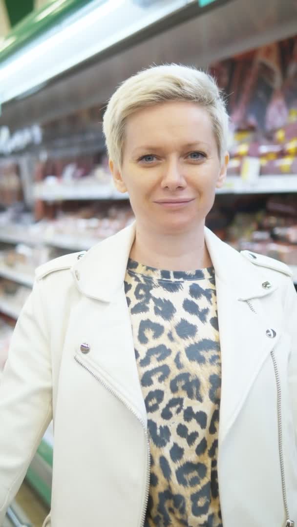 Disparo vertical. retrato de mujer con estilo en el supermercado con un carrito de comestibles — Vídeos de Stock