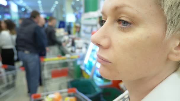 Portret van een vermoeide vrouw in de supermarkt. close-up — Stockvideo