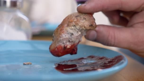 Gros plan. homme tient un morceau de viande frite avec sa main. trempette dans la sauce — Video