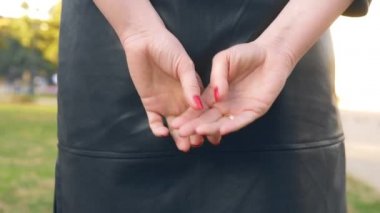 Ellerinizi yakın tutun. Kadın sokakta dikilirken alyansını çıkarıyor.