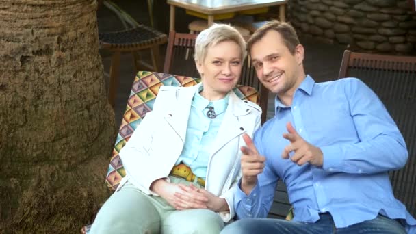 Bella coppia uomo e donna guardando la fotocamera seduta in un caffè all'aperto — Video Stock