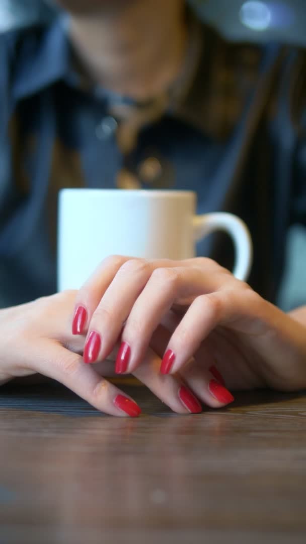 Függőleges lövés. Közelről. A nő leveszi a jegygyűrűjét egy kávézóban ülve. — Stock videók