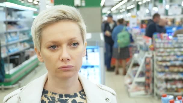 Портрет уставшей женщины в супермаркете. Крупный план — стоковое видео