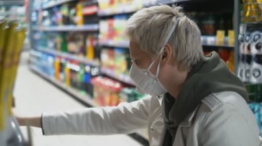 Marketteki tıbbi maskeli kısa saçlı sarışın kadın. salgın