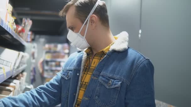 Un uomo in maschera medica al supermercato. pandemia — Video Stock