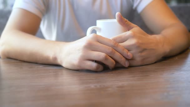 Nahaufnahme. der Mann trägt einen Ehering, sitzt in einem Café. — Stockvideo