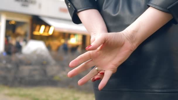 Närbild händer. kvinna tar av en vigselring när du står på gatan — Stockvideo