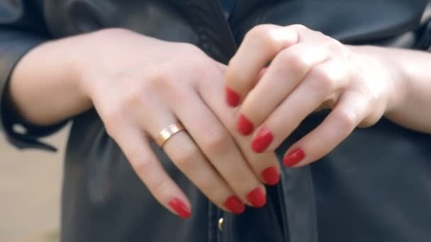 Руки крупным планом. Женщина снимает обручальное кольцо, стоя на улице — стоковое видео