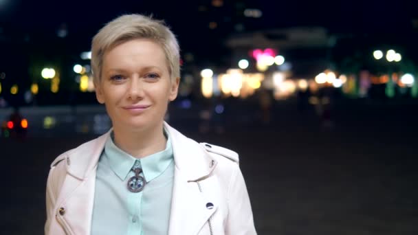 Portret van stijlvolle jonge vrouw op een straat in de stad in de avond. — Stockvideo