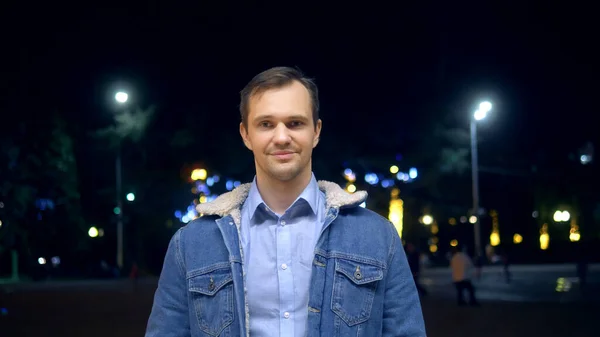 Όμορφος άντρας με σακάκι σε δρόμο της πόλης τη νύχτα κοιτάζοντας την κάμερα. — Φωτογραφία Αρχείου