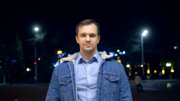 Όμορφος άντρας με σακάκι σε δρόμο της πόλης τη νύχτα κοιτάζοντας την κάμερα. — Φωτογραφία Αρχείου