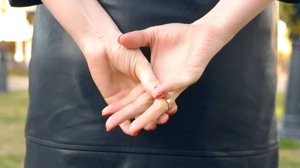 De cerca las manos. mujer se quita un anillo de bodas mientras está de pie en la calle — Foto de Stock