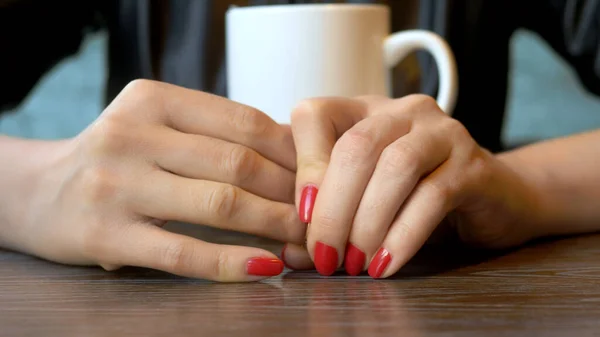 Primer plano. la mujer se quita su anillo de bodas sentada en un café —  Fotos de Stock