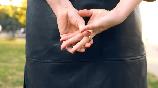 Closeup hands. woman takes off a wedding ring while standing on the street — Stock Photo, Image