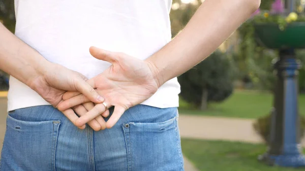 Närbild av händerna. mannen tar av sig sin vigselring stående på gatan. — Stockfoto