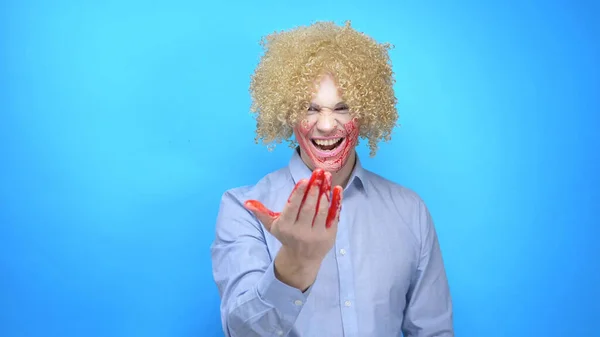 a man with makeup and a wig rubs his face with blood, shows, come here