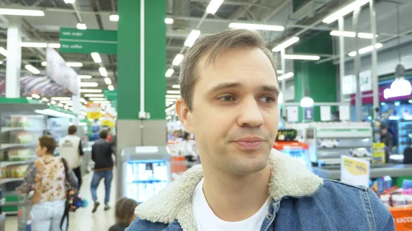 Gros plan. portrait d'un homme fatigué au supermarché. en regardant autour — Photo