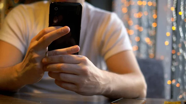 Мужчина снимает обручальное кольцо, читает сообщение по телефону — стоковое фото