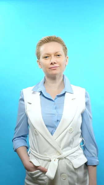 Senkrechtschuss. Blonde Frau ohne Make-up auf blauem Hintergrund. — Stockfoto
