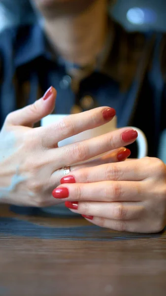 Disparo vertical. Primer plano. la mujer se quita su anillo de bodas sentada en un café — Foto de Stock