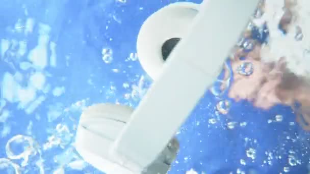 A férfi bedobta a fejhallgatót a víz alá és kivette. víz alatt — Stock videók