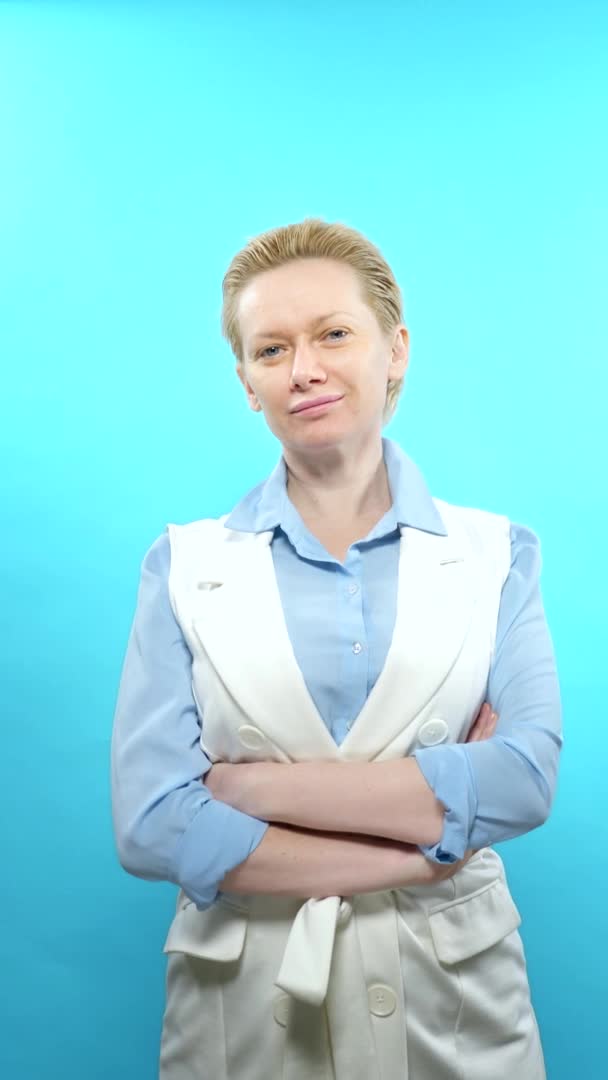 Senkrechtschuss. Blonde Frau ohne Make-up auf blauem Hintergrund. — Stockvideo